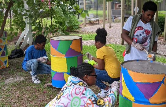 Educational Resources Teens painting a barrel at Next Step to Success program